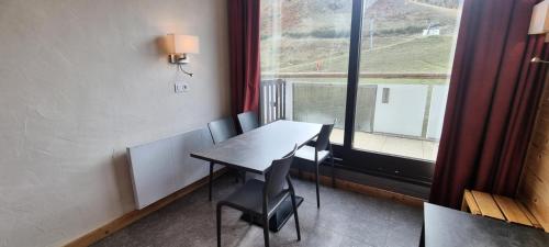 une table et des chaises dans une pièce avec une fenêtre dans l'établissement Résidence Etoile - Studio pour 4 Personnes 954, à Aime La Plagne