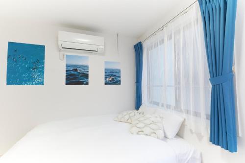 a bedroom with blue curtains and a bed at Sky Up Oshiage by Tranova in Tokyo