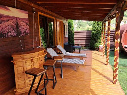 a porch of a house with benches on it at La Grasu' Sauna&ciubar in Dodeni