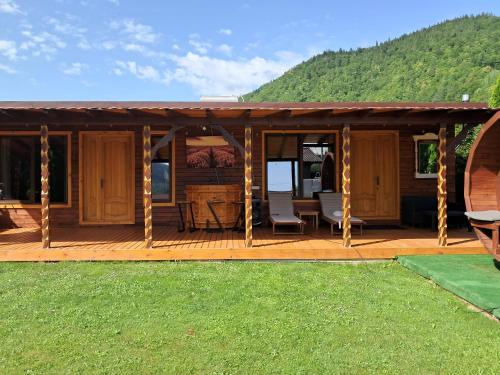 a wooden deck with a house with a mountain at La Grasu' Sauna&ciubar in Dodeni