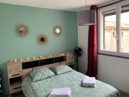 a bedroom with a bed and two mirrors on the wall at T2 Cosy - 70m2 au Coeur de ville in Graulhet
