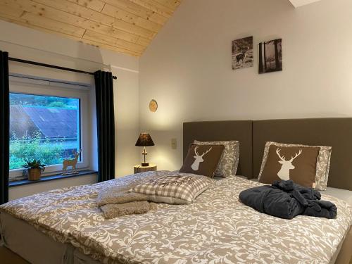 ブルク・ロイラントにあるdie Mühle - Holiday home with wellness in Ourenの窓のある大きなベッドのある寝室