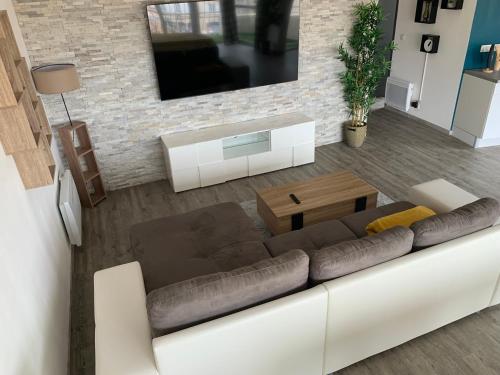 a living room with a couch and a table at T2 Cosy - 70m2 au Coeur de ville in Graulhet