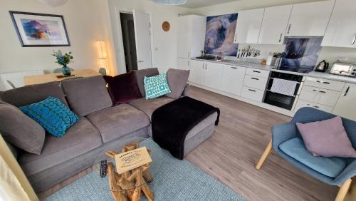 a living room with a couch and a kitchen at Number 15 Luxurious Two Bedroom Apartment in Exmouth