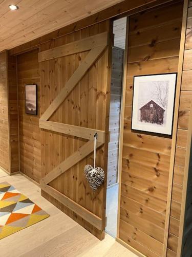 a room with a wooden wall with a wooden door at ChaletMons, stor trivelig leilighet i Myrkdalen in Vossestrand