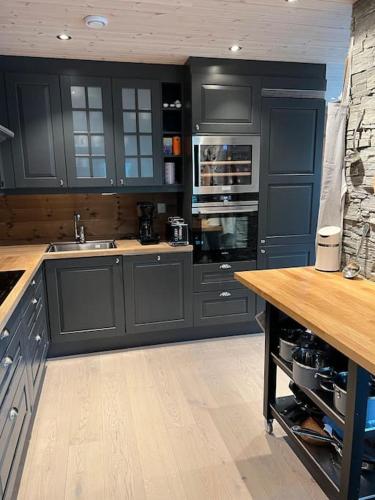 a kitchen with black cabinets and a wooden counter top at ChaletMons, stor trivelig leilighet i Myrkdalen in Vossestrand