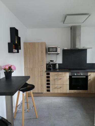 une cuisine avec une table et une cuisinière four supérieur dans l'établissement Maison proche centre et plages, à La Tranche-sur-Mer