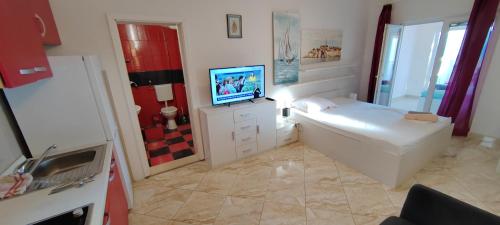 a bathroom with a tub and a television in it at Apartmani ANDRIJA in Živogošće