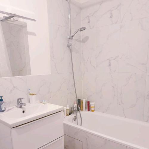 une salle de bain blanche avec une douche et un lavabo dans l'établissement Location Blois, à Blois