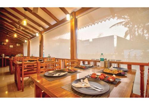 a long wooden table with plates of food on it at Portu Stay Goa in Vagator