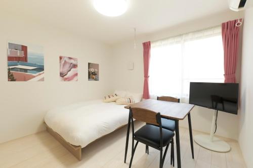 a bedroom with a bed and a desk with a television at Sky Up Oshiage by Tranova in Tokyo