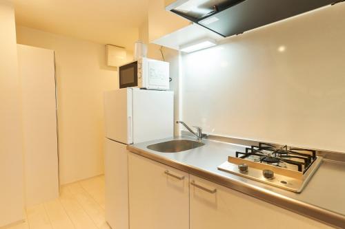 a small kitchen with a sink and a refrigerator at Sky Up Oshiage by Tranova in Tokyo