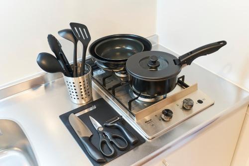 a stove with two pots and pans on it at Sky Up Oshiage by Tranova in Tokyo