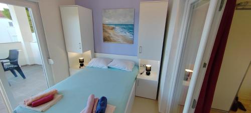 a bedroom with a white bed and a mirror at Apartmani ANDRIJA in Živogošće