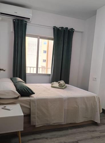a bedroom with a bed with green curtains and a window at ALEJANDRO PLAYA Gandia 1 in Los Mártires