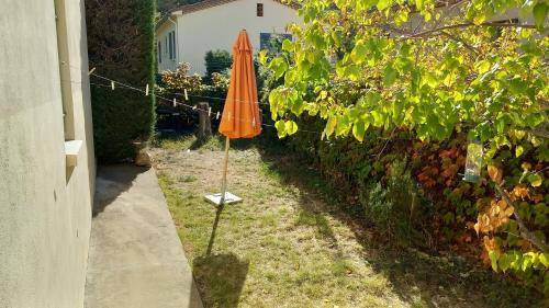 un parapluie orange posé dans l'herbe à côté d'une clôture dans l'établissement Hébergement radieux, à Prades