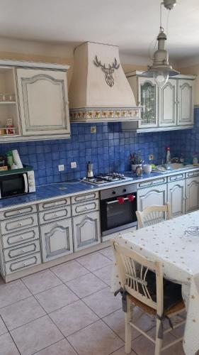 une cuisine avec des armoires blanches et une table à l'intérieur dans l'établissement Hébergement radieux, à Prades