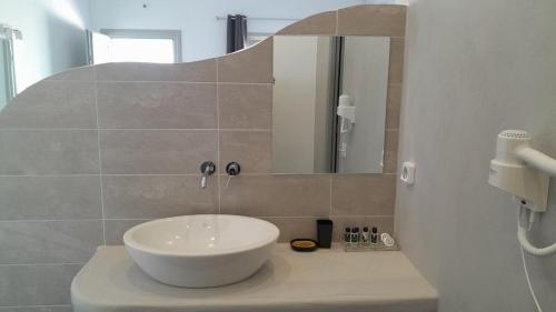 a bathroom with a white sink and a mirror at Manos Small World in Firostefani