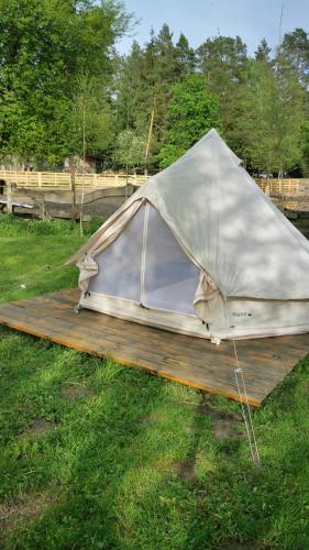 a tent on a wooden deck in the grass at pole namiotowe Stajnia Kaliska in Łochów