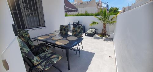 a patio with a table and chairs and a palm tree at Apartamento Playa Bonita in Torrevieja