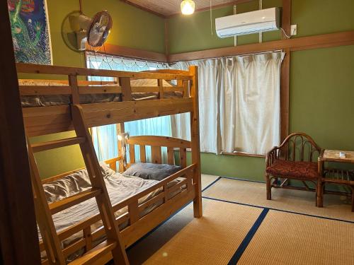 a bedroom with two bunk beds and a window at ゲストハウス千倉のおへそ in Chikura