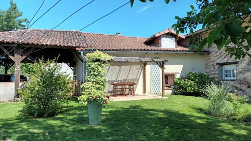 Saint-ThomasにあるGîte d'en Pouillacの庭にテーブルとパティオが付いた家