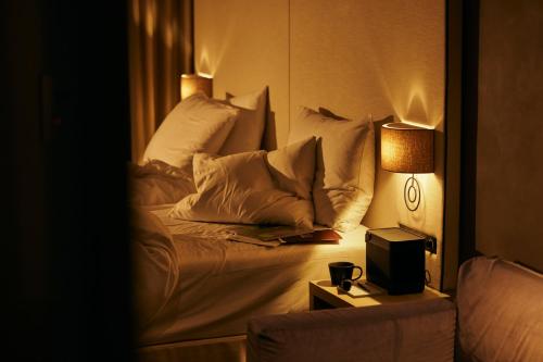 a bedroom with a bed with pillows and a lamp at NOHGA HOTEL UENO TOKYO in Tokyo