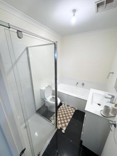 a bathroom with a shower and a toilet and a sink at City & Beach Retreat in Newport