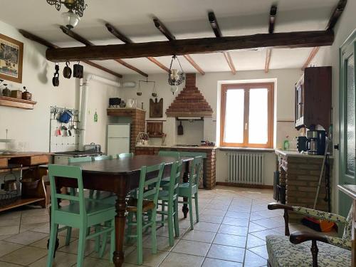 a kitchen with a wooden table and green chairs at Casa Vacanze Cascina Campagnola in Pozzolengo