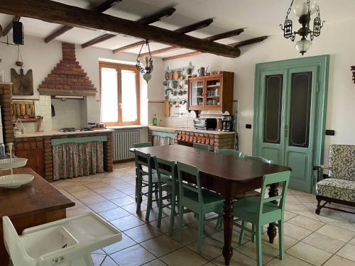 a kitchen with a wooden table and green chairs at Casa Vacanze Cascina Campagnola in Pozzolengo