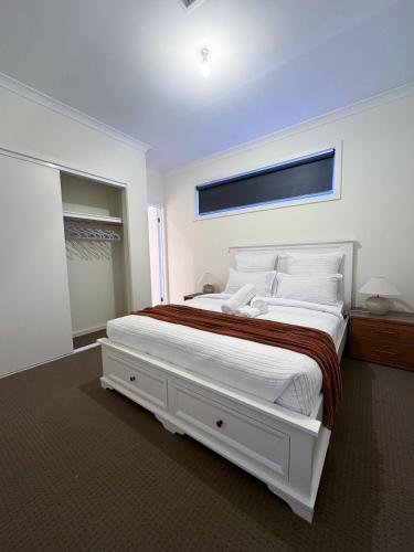a white bedroom with a large bed with white pillows at City & Beach Retreat in Newport