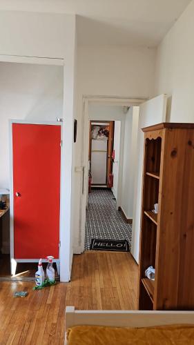 an empty room with a red door and a hallway at Maison d'hôte la Courneuve in La Courneuve