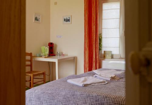 une chambre avec un lit, un bureau et une fenêtre dans l'établissement Les chambres du Moulin, à Arleux-du-Nord