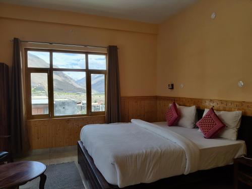 a bedroom with a large bed with a window at Hotel Spiti Heritage in Kaza