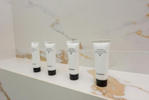a row of four tubes of mascara on a shelf at Kevin's ApartHotel in Vlorë
