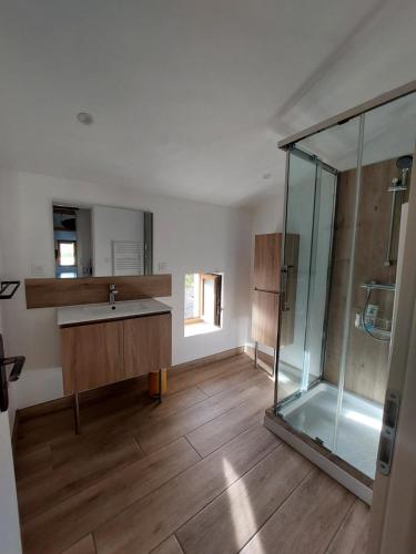 une salle de bain avec un lavabo et une douche en verre dans l'établissement La Grange, à Saint-Vincent-de-Barrès