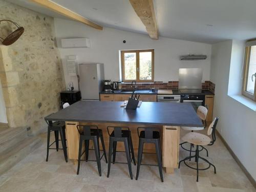 une cuisine avec une grande table et des chaises en bois dans l'établissement La Grange, à Saint-Vincent-de-Barrès