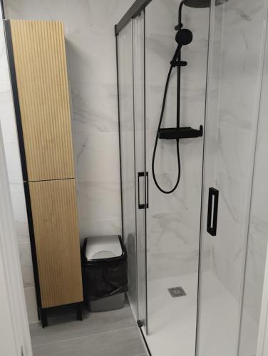 a shower with a glass door and a stool in a bathroom at ALEJANDRO PLAYA Gandia 1 in Los Mártires