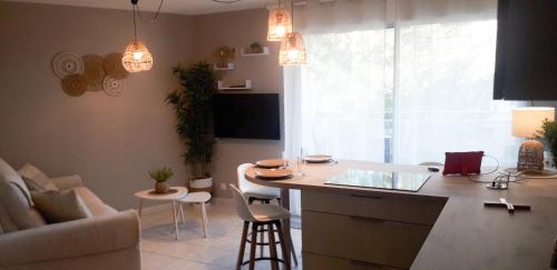 - une cuisine et un salon avec un comptoir et une table dans l'établissement Studio Le Charentais - logement de vacances 4 personnes bord de mer, à Vaux-sur-Mer