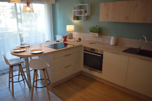 - une cuisine avec un comptoir, un évier et une table dans l'établissement Studio Le Charentais - logement de vacances 4 personnes bord de mer, à Vaux-sur-Mer