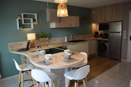 une cuisine avec une table et des chaises dans une cuisine dans l'établissement Studio Le Charentais - logement de vacances 4 personnes bord de mer, à Vaux-sur-Mer