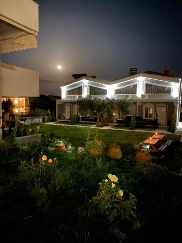 a house at night with a garden in front of it at The House Of The Roses in Yerakiní