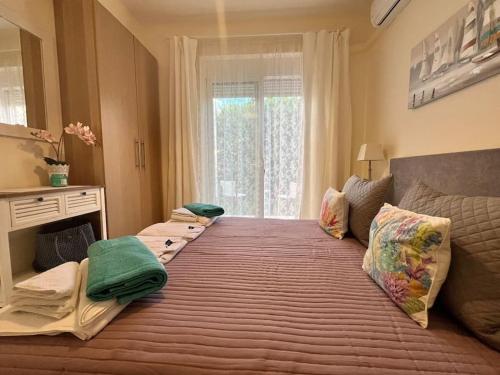 a large bed in a room with a large window at Colibri seafront villa with pool in Nopíyia