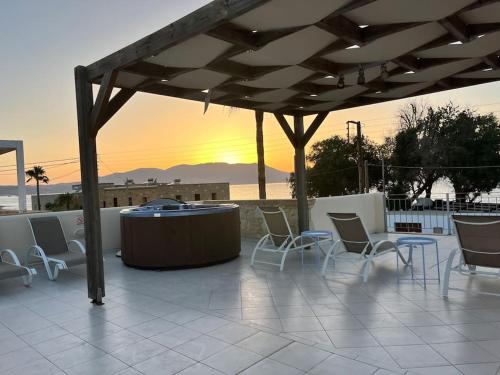 a group of chairs and a hot tub on a patio at Colibri seafront villa with pool in Nopíyia