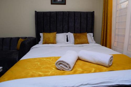 a bedroom with a bed with two towels on it at Studio Apartment near the Airport in Nairobi