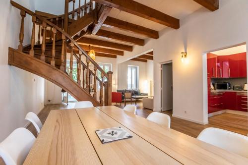une salle à manger avec une table en bois et un escalier dans l'établissement Maison familiale avec grand jardin, 2min de la mer, à Marseille