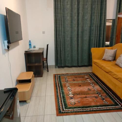 a living room with a couch and a table at Studio Apartment near the Airport in Nairobi