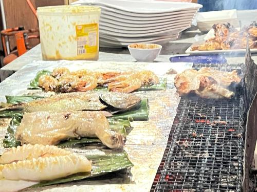 a table topped with lots of different types of seafood at Mama's Chalet Pulau Perhentian Besar in Perhentian Island