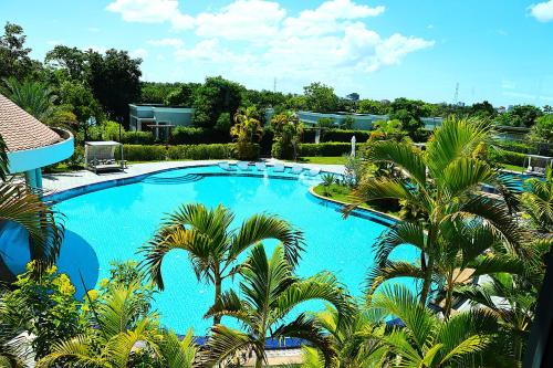 a view of a swimming pool with palm trees at Castle Bayview Resort & Spa in Kampot