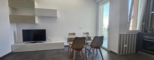 a living room with a table with chairs and a television at Forte2110 in Misano Adriatico